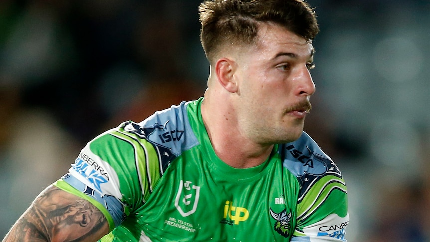 Curtis Scott running with a ball in a Canberra Raiders jersey.