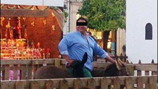 A man posing on a donkey
