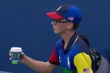 A ball boy holds a coffee cup intended for Venus Williams.