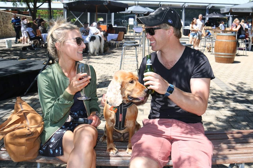 Alixandria Schuppan and Jesse Rogerson share a drink alongside their dog.