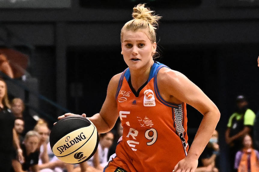 A Townsville Fire WNBL player dribbles the ball against the Southside Flyers.