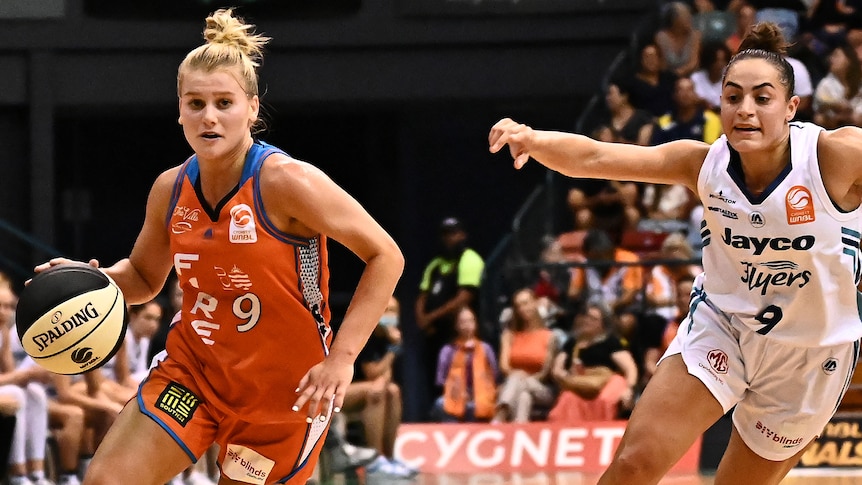 A Townsville Fire WNBL player dribbles the ball against the Southside Flyers.