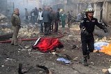 Iraqi civil defence personnel gather at the site of a bomb attack in Baghdad's north-west