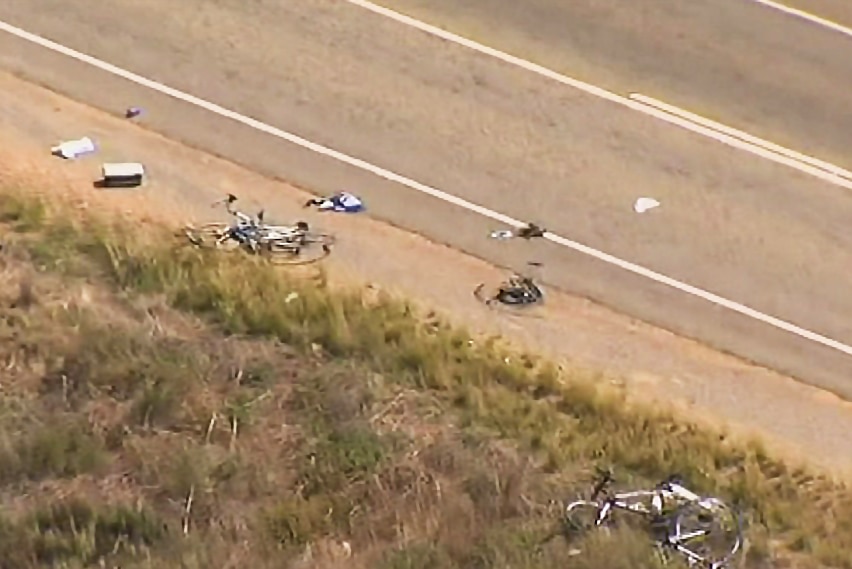 Damaged bicycles lie by the side of the road