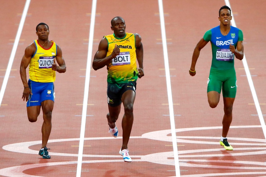 Usain Bolt cruises over the finish line ahead ofAlex Quinonez (L) and Aldemir da Silva Junior.