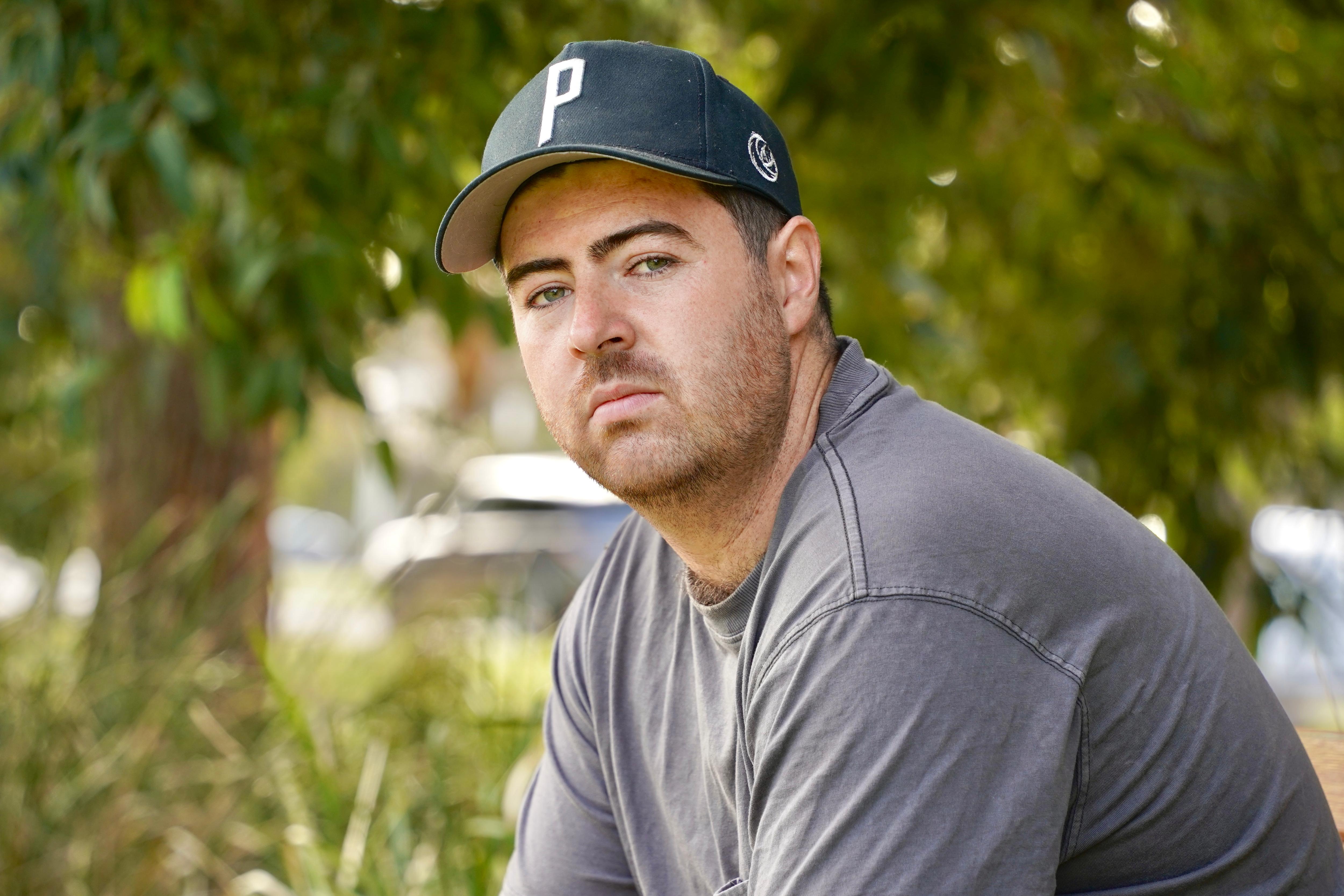 A man holding his licence in a park