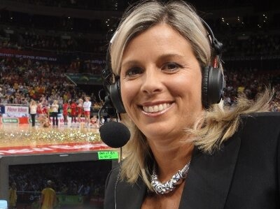 woman in headphones and microphone at netball match in stadium