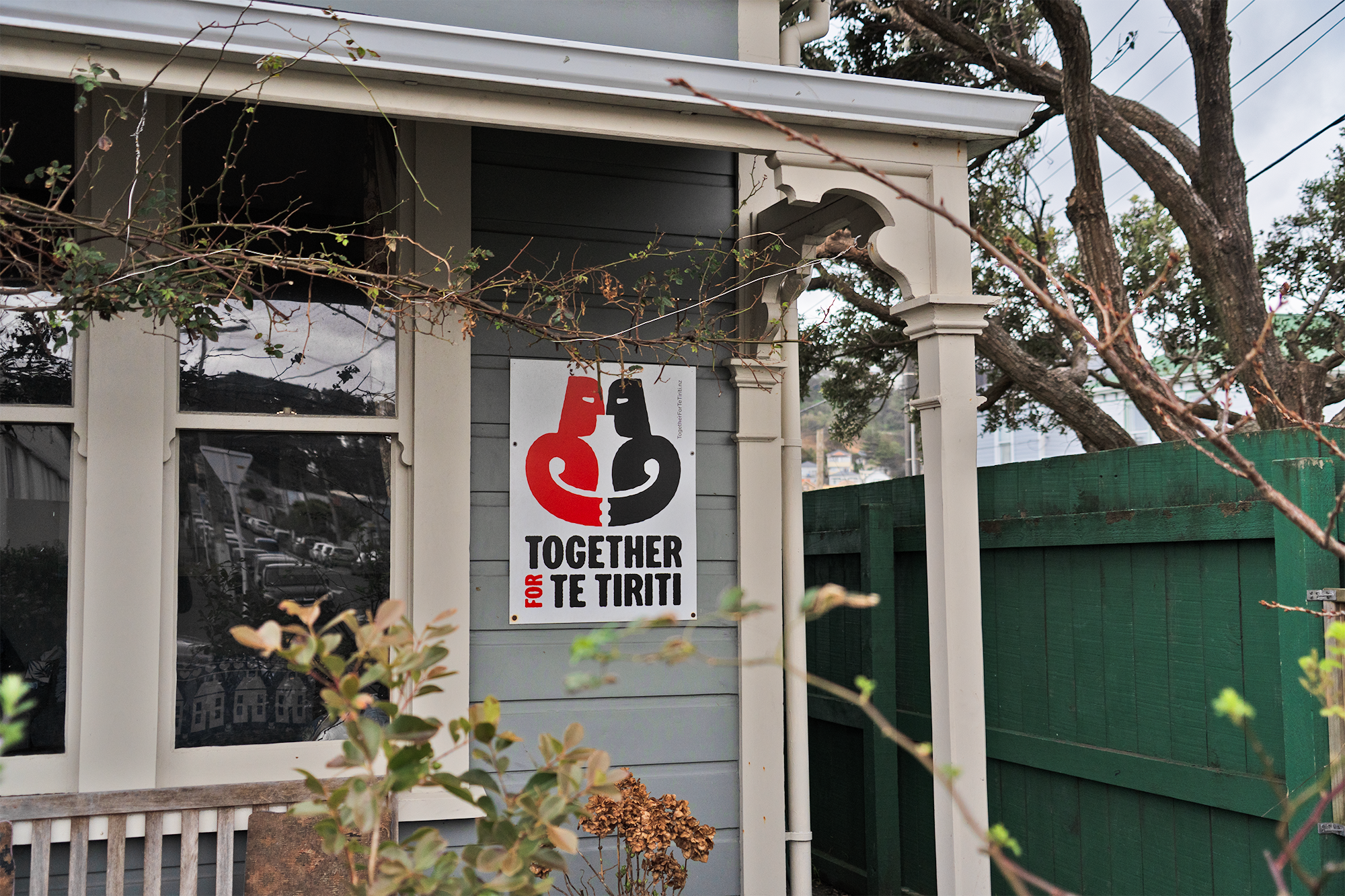 A poster of Together For Te Tiriti on a house.