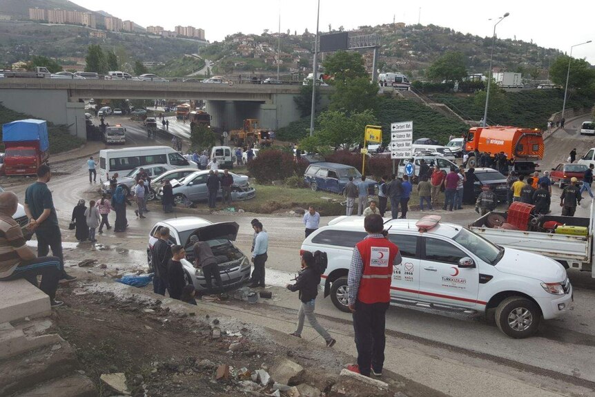 Rescue workers and people are tending to broken down cars on streets after flooding in Ankara.