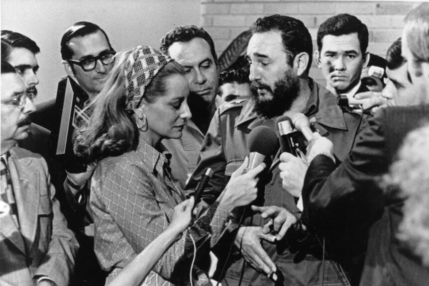 Barba Walters and other reporters hold microphones up to Fidel Castro while interviewing him in Cuba