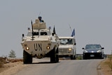 Two UNIFIL vehicles are seen driving on a road near Lebanon's border with Israel.