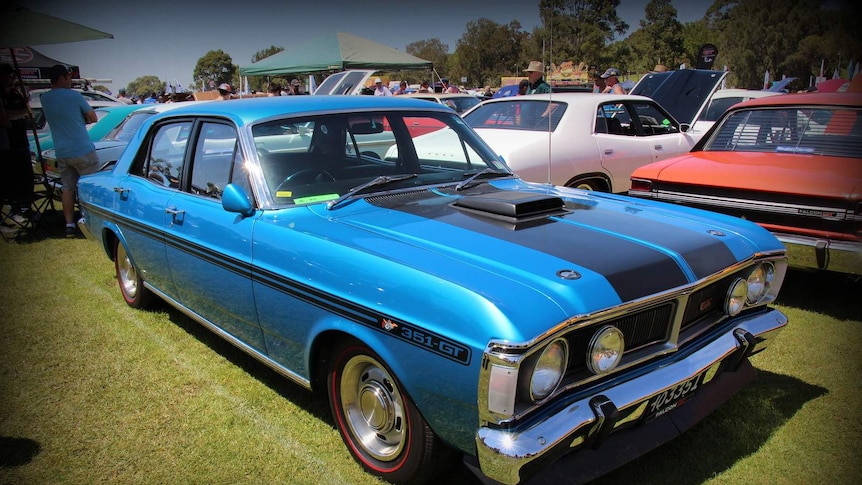 An electric blue 1971 Ford XY Falcon GT Sedan sits in sunshine.