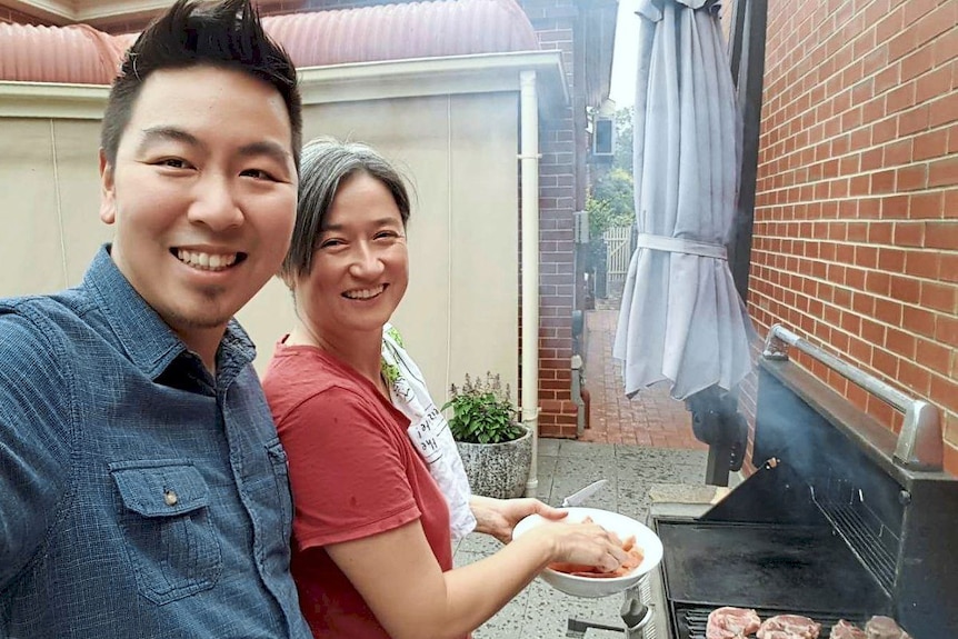 Foreign Minister Penny Wong stands with her brother at a barbecue