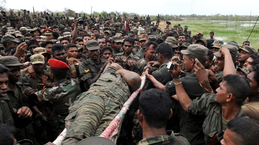 The body of Vellupillai Prabhakaran is carried on a stretcher through a group of Sri Lankan soldiers