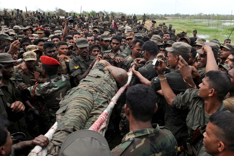 The body of Vellupillai Prabhakaran is carried on a stretcher through a group of Sri Lankan soldiers