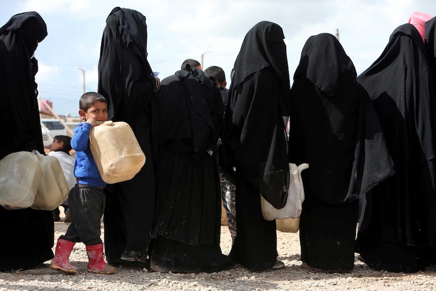 Women in veils in a line holding cans, with a little boy in a blue jumper in the foreground