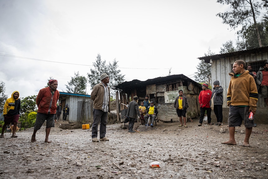People standing in a muddy village 