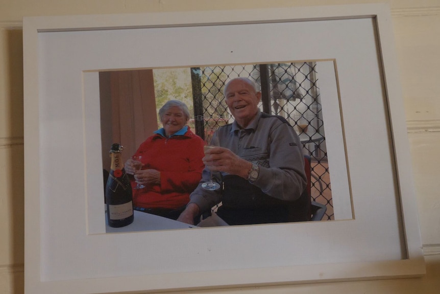 A photo of an old man and woman smiling in a photo.