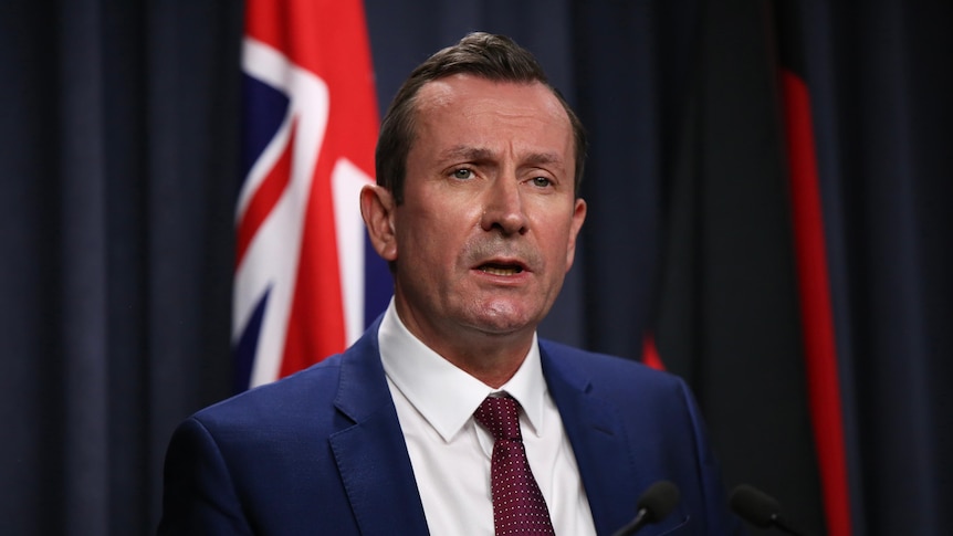 Mark McGowan speaks at a press conference wearing a blue suit and red tie