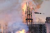Flames and smoke rise as the spire on Notre Dame cathedral collapses
