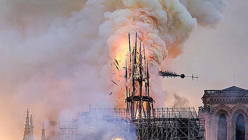 Flames and smoke rise as the spire on Notre Dame cathedral collapses