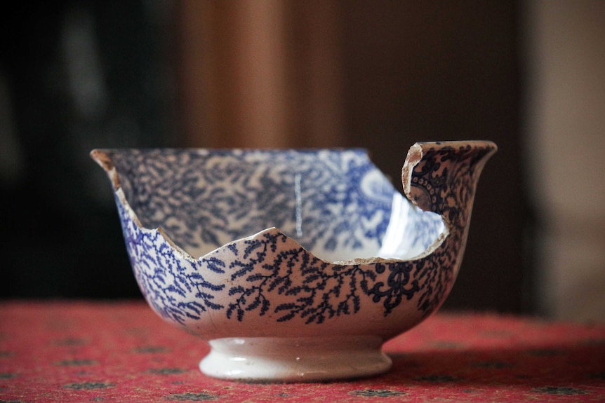 A blue china bowl glued back together.