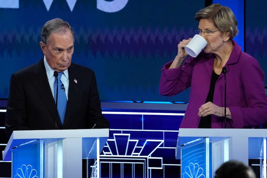 Former New York City Mayor Mike Bloomberg stands near Senator Elizabeth Warren