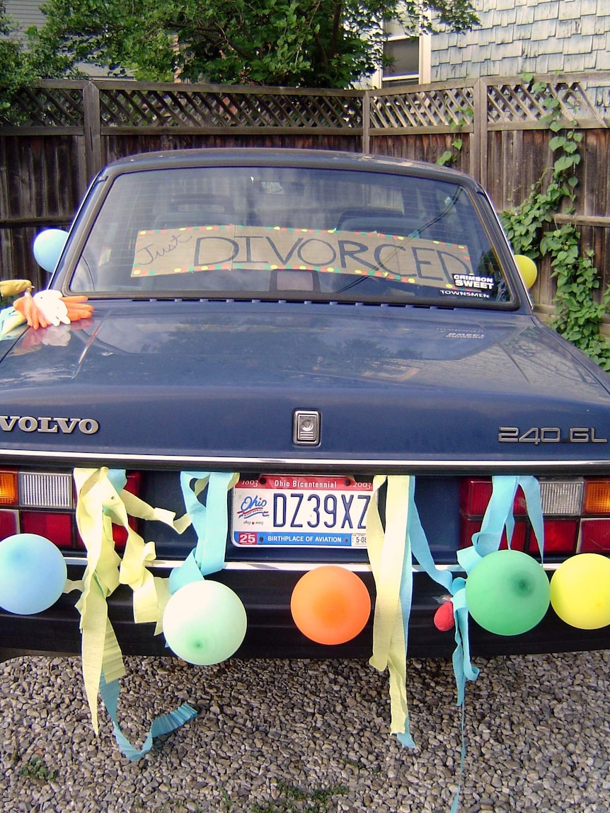 A car with a just divorced sign and balloons
