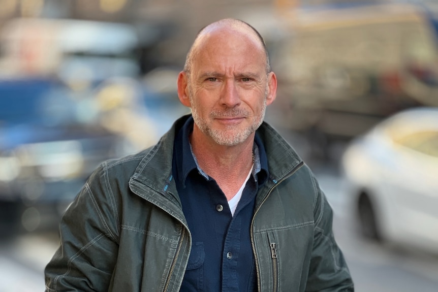 Author Bill Hayes sitting on a green block