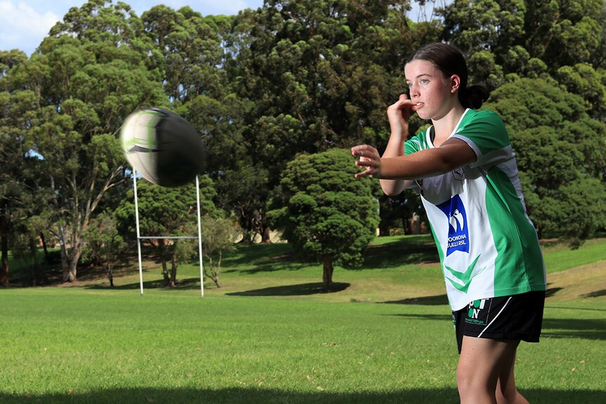 Jorja Bostock throws a pass on a football oval in Woonona.