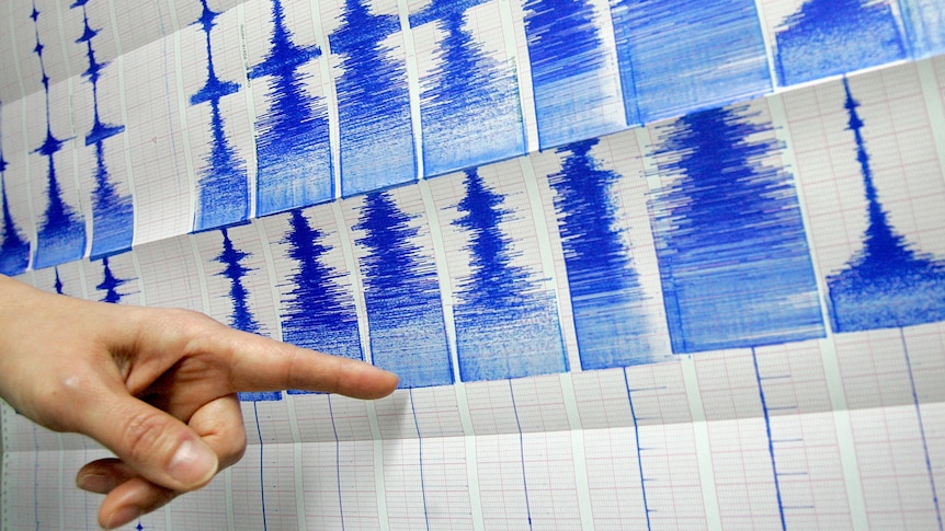 Man points to quake chart