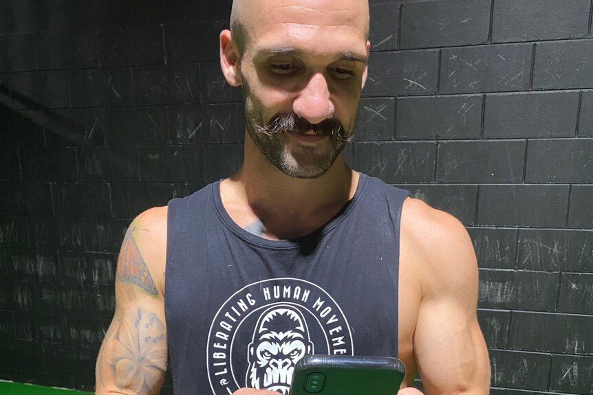 Personal trainer Mark Gordon uses an app on his mobile phone to connect with clients.