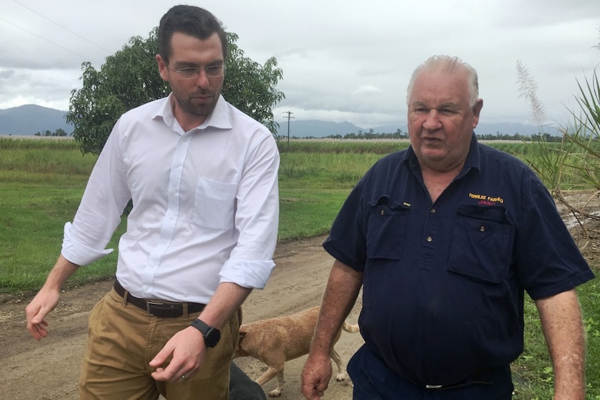 A scientist walks alongside cane grower Peter Jackson on his Tully cane farm