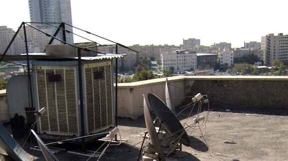 Illegal satellite dishes are set up on a roof in the Iranian capital of Tehran.