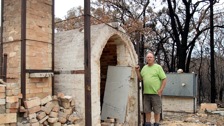 Steve Harrison stands next to the remains of his pottery building in Balmoral village.