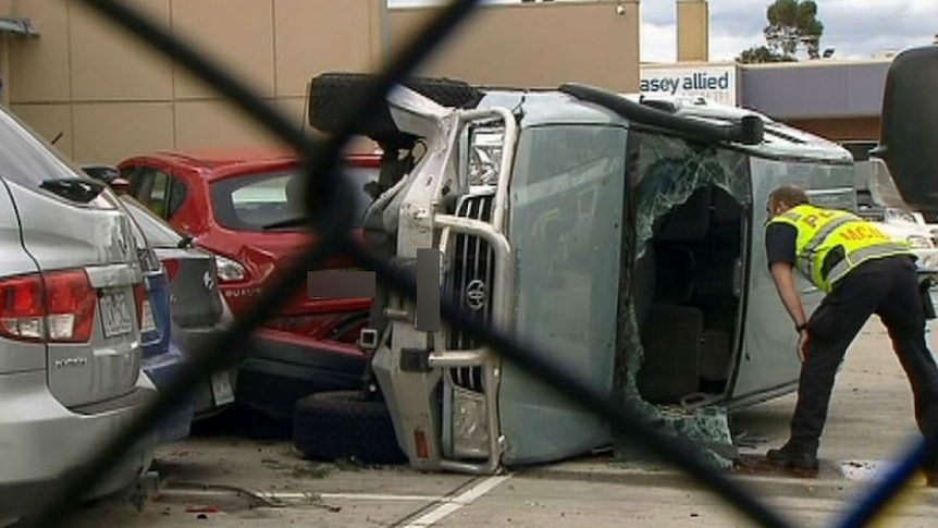 A police officer looks in the four-wheel-drive that crashed in a Berwick carpark.