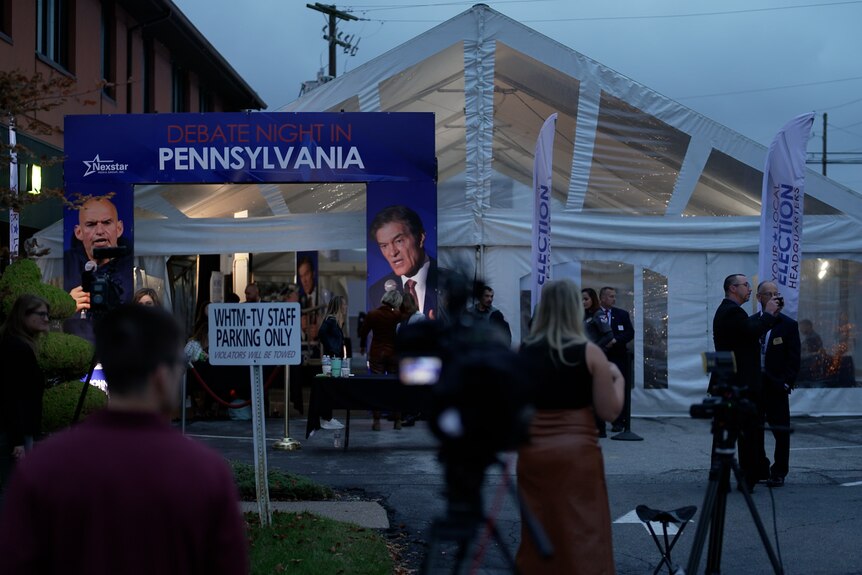 Media lines up outside of a tent that says "debate night in Pennsylvania"