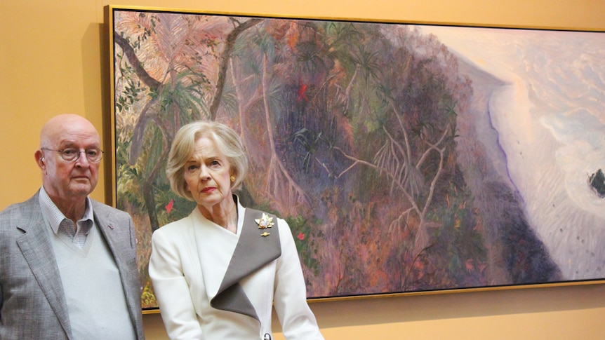 William Robinson and Dame Quentin Bryce stand in front of Robinson's artwork.