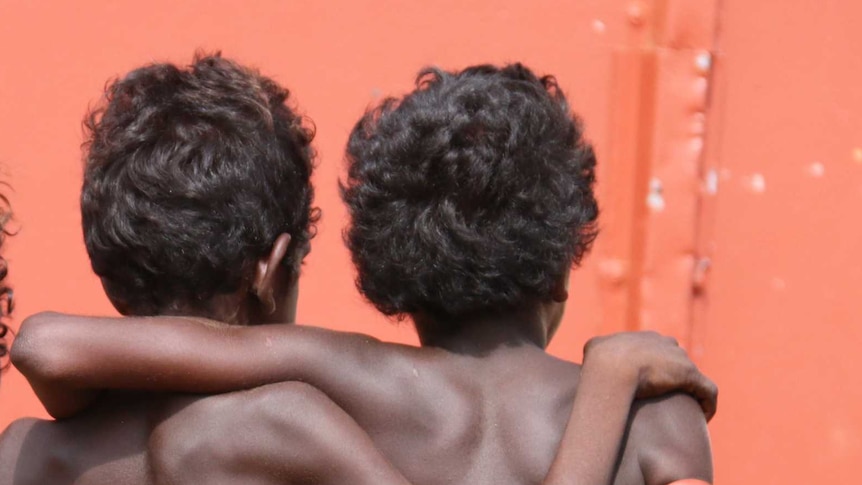 a generic photograph showing the backs of three indigenous children