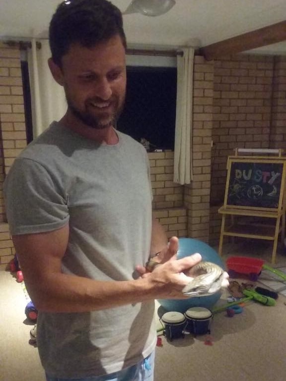 A man holds a blue-tongue lizard