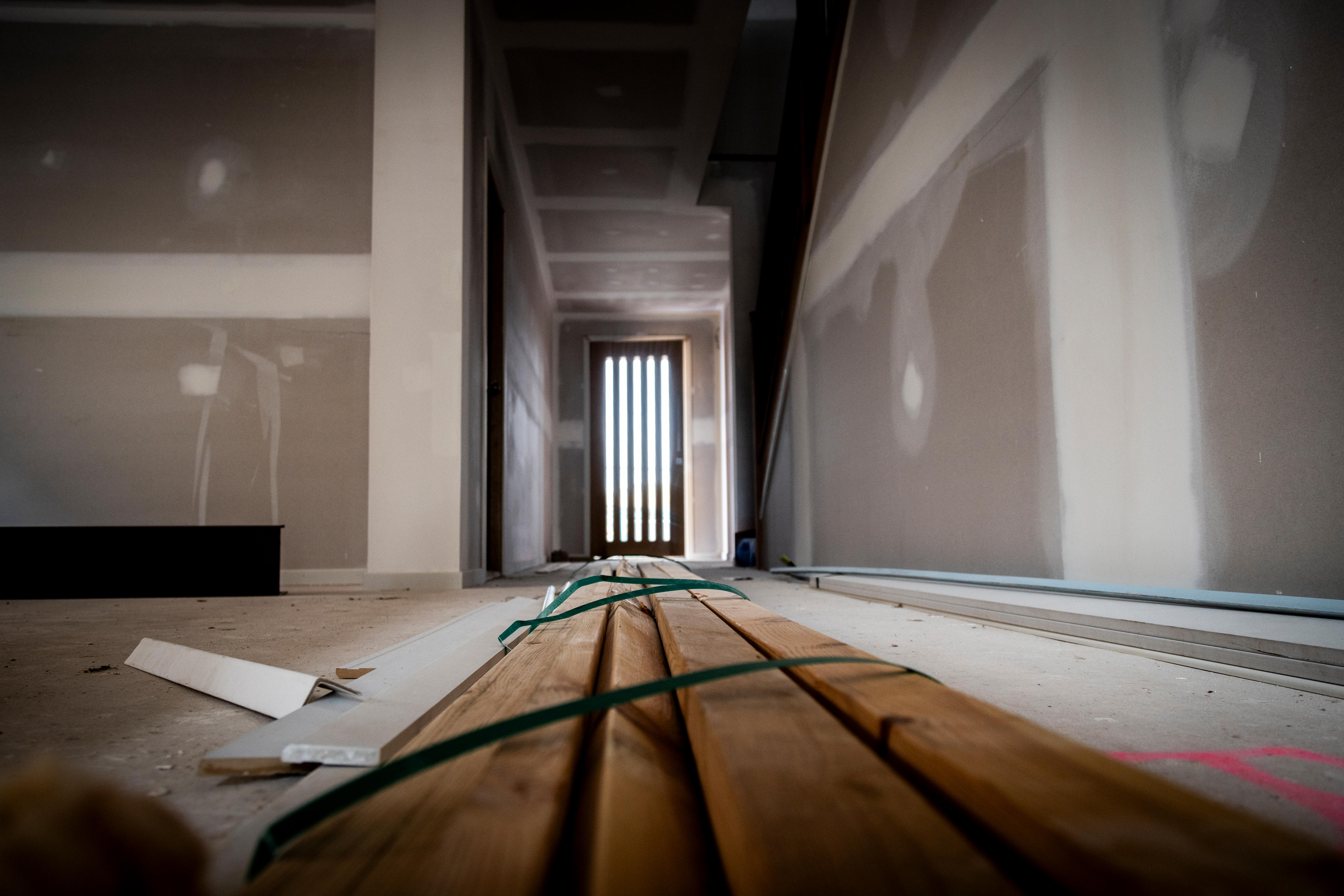 Planks of wood on the floor of a partly built house.