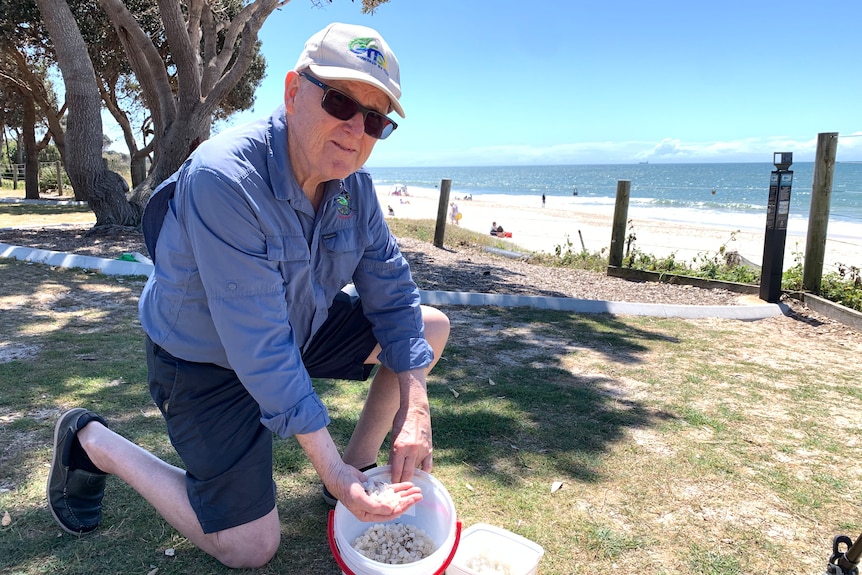 man bending down with handful of plastic