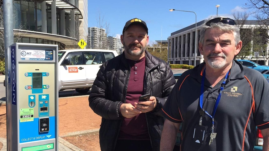Businessmen Marcus Dawe and Tom Bedford at a parking ticket machine in Canberra.