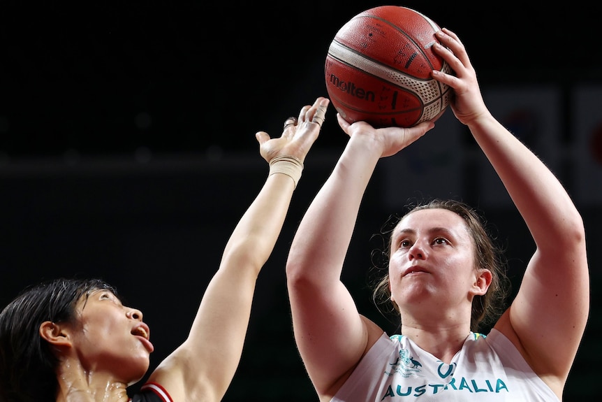 An Australian female wheelchair basketball players holds the ball in two hands as she prepares to shoot.