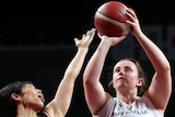 An Australian female wheelchair basketball players holds the ball in two hands as she prepares to shoot.