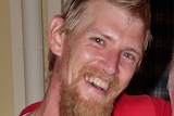 A headshot of a man with blonde-red hair and beard