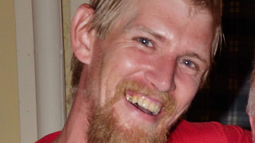 A headshot of a man with blonde-red hair and beard