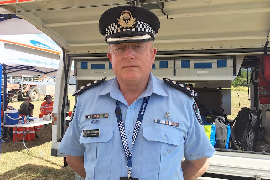 Queensland police Inspector Rolf Straatemeier stands in front of a police van.