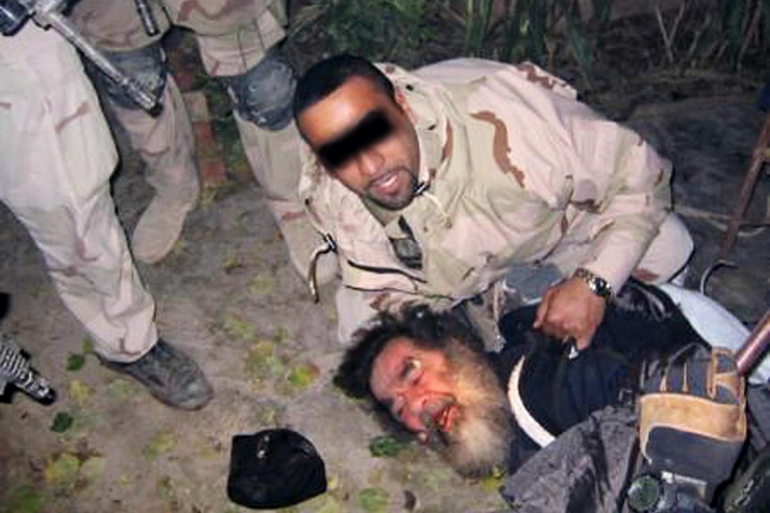Saddam Hussein is dragged out of his hiding place by US troops