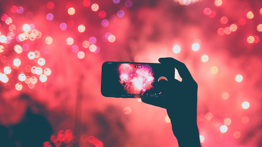 Someone takes a video of fireworks on an iPhone.